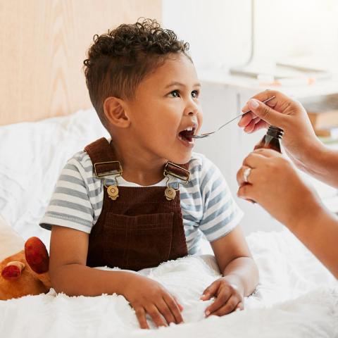 Kid gets medicine on a spoon